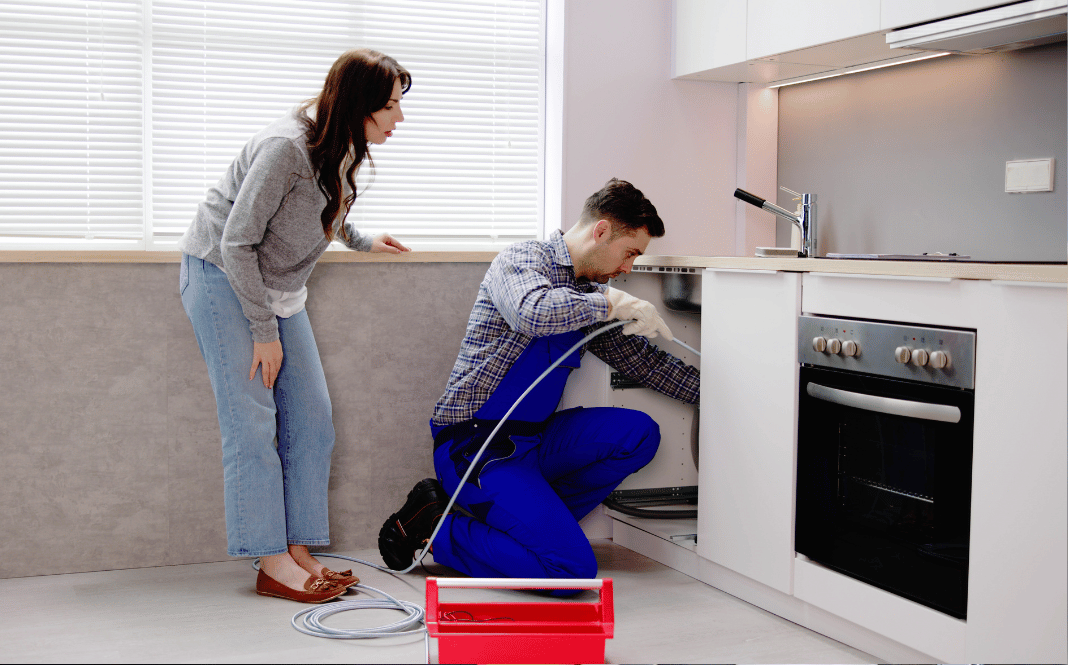 Plumber cleaning drain in a residential house